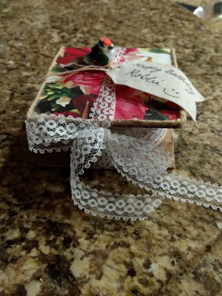 gift wrapping ideas, this one shows bright floral paper on the exterior with a lace tie and faux bird detail