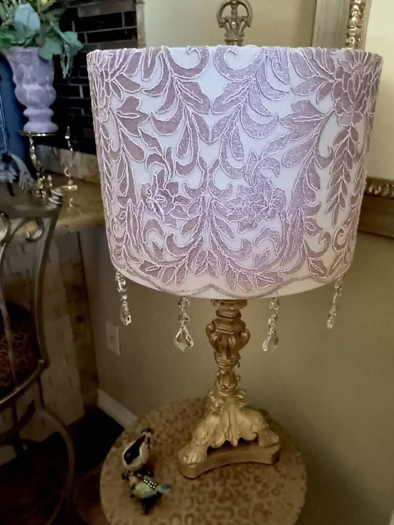 Light blush pink venice lace covering a lampshade with crystals hanging from the bottom