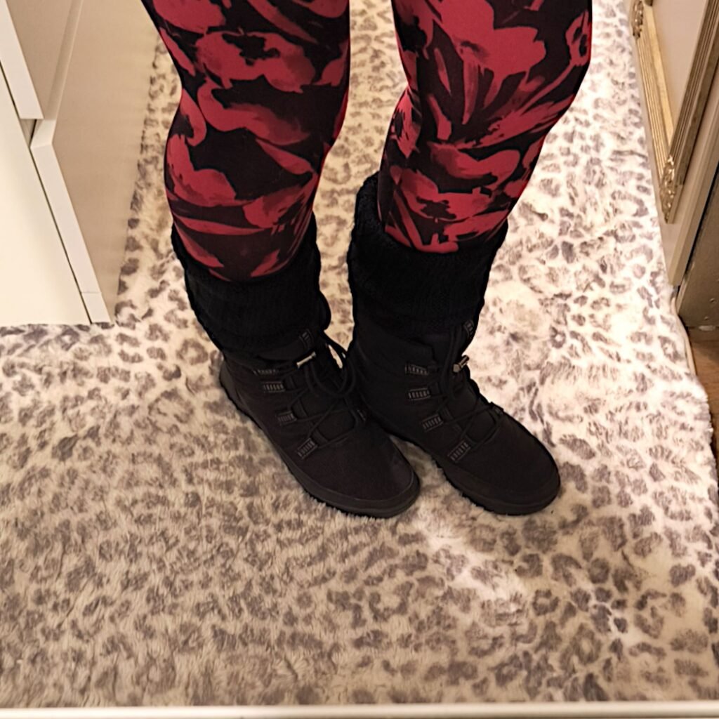 woman wearing black and red leggings with black leg warmers and black flat boots