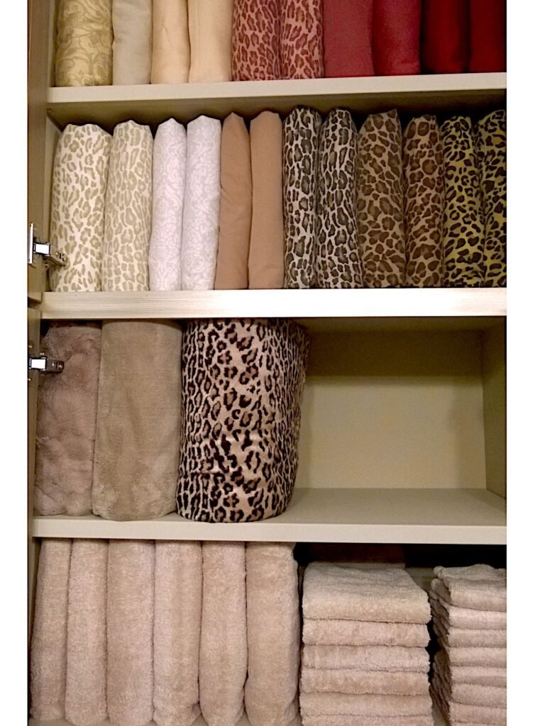 Organized linen cabinet with vertically stacked sheets and towels