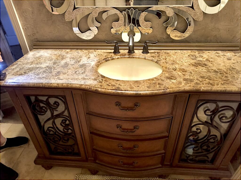 Large marble bathroom vanity counter prior to updates with metallic foil