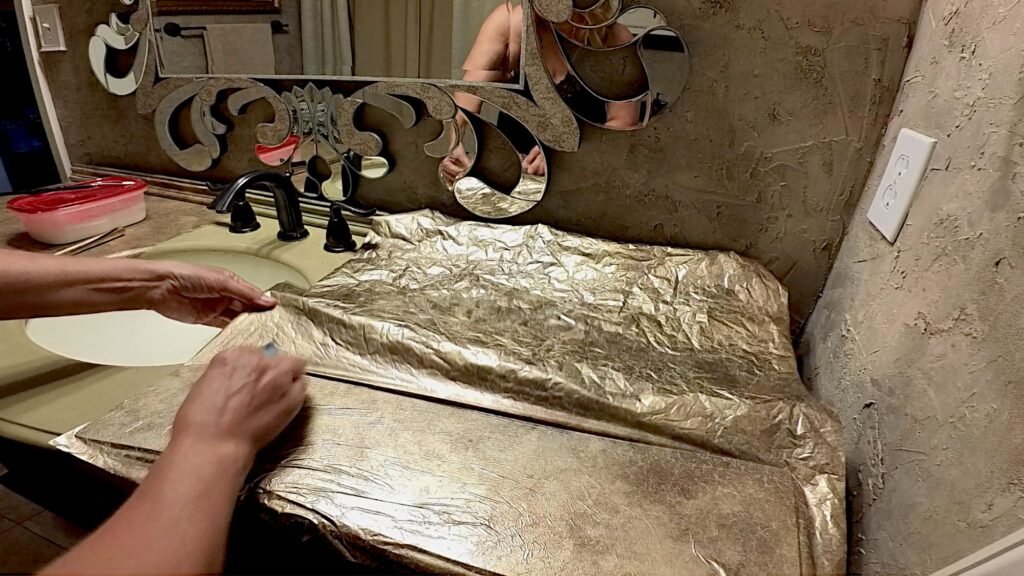 Foil being applied from front to back on a bathroom vanity